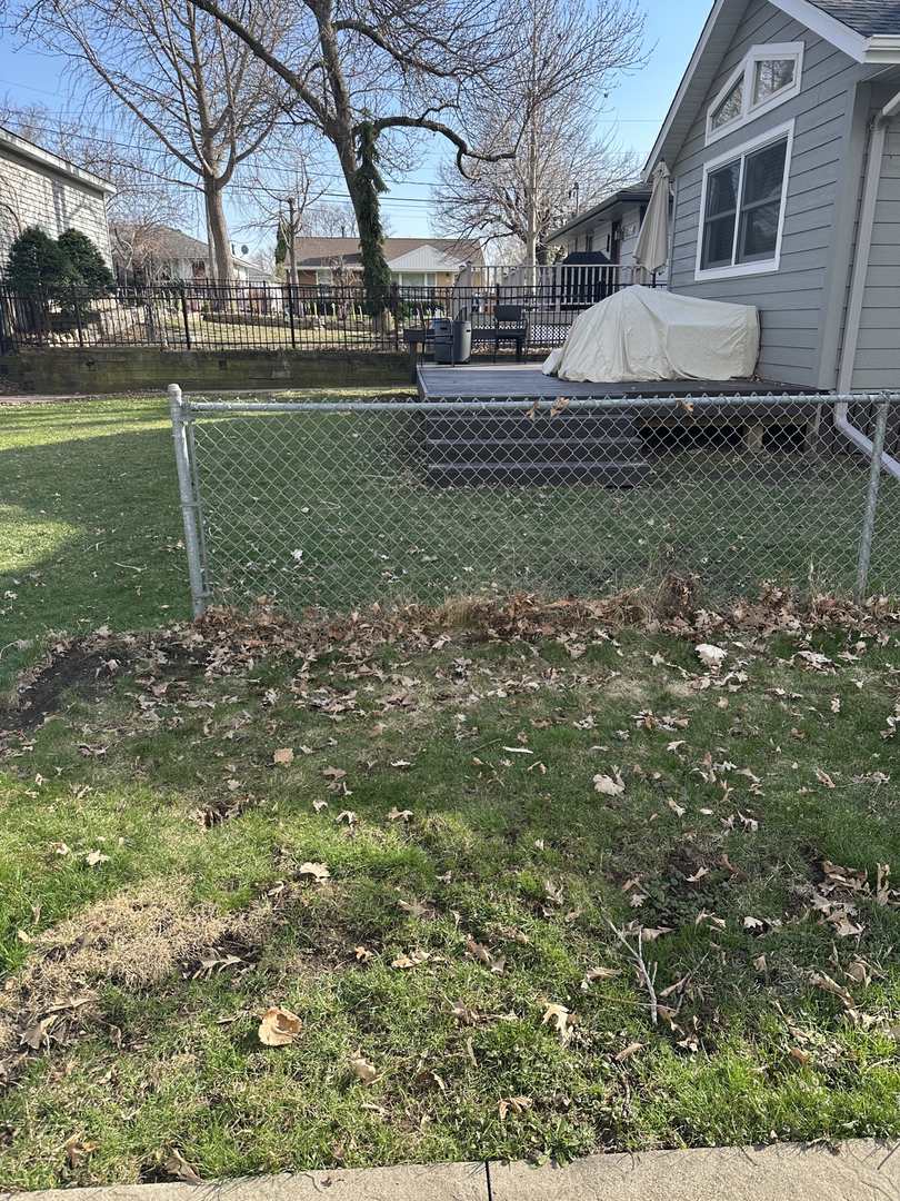 Chain-link fence across a backyard before posts were pulled