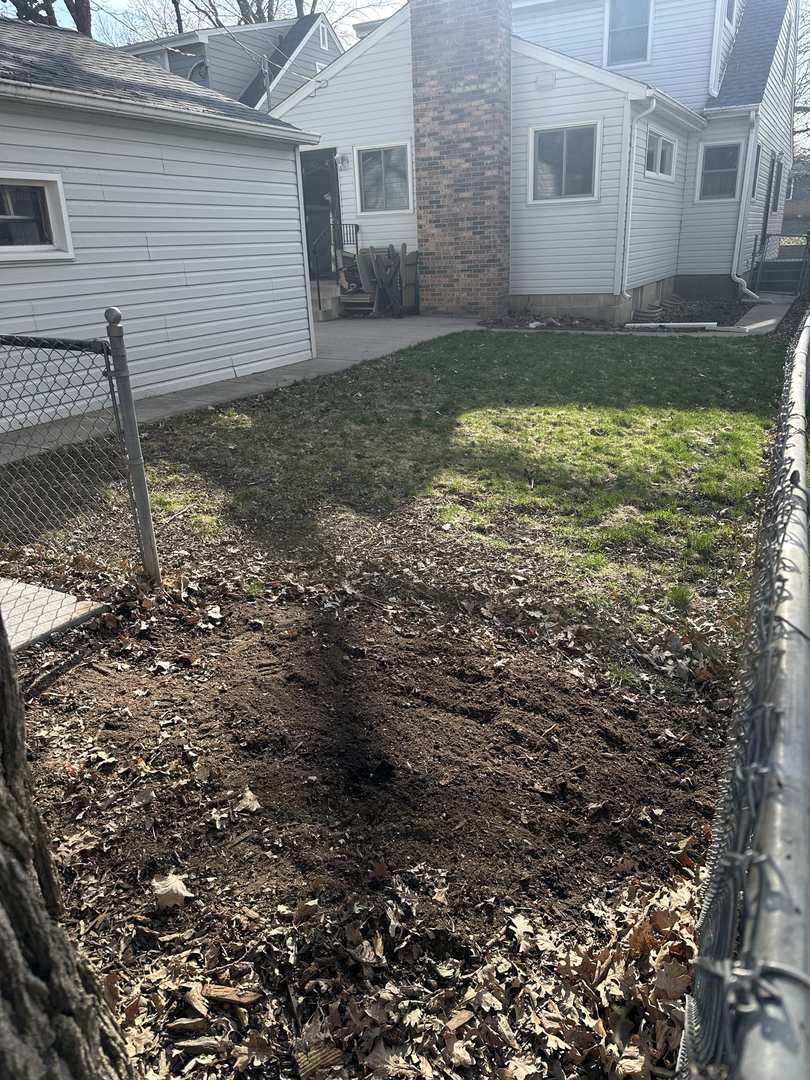 Dirt strip where fence posts were pulled from a backyard