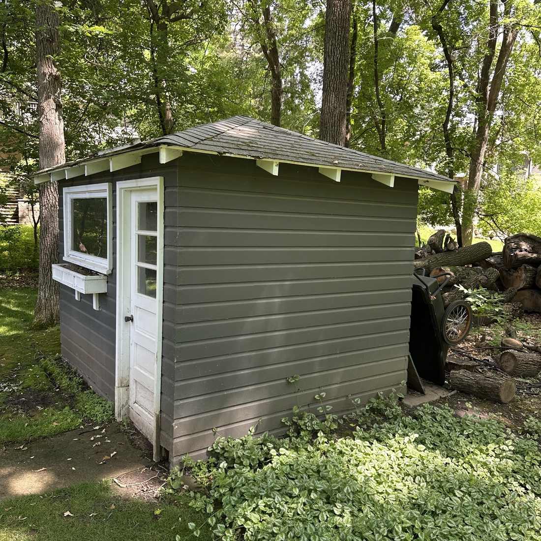 8x10 gray garden shed in a Twin Cities backyard before teardown